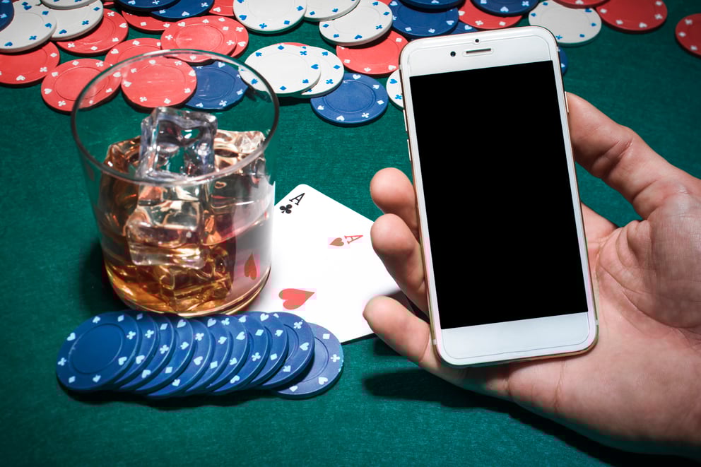 https://sibermate.com/hubfs/man-s-hand-holding-cellphone-poker-table-with-whisky-glass.jpg